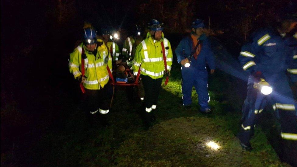 woman on a stretcher, being carried to safety by emergency services