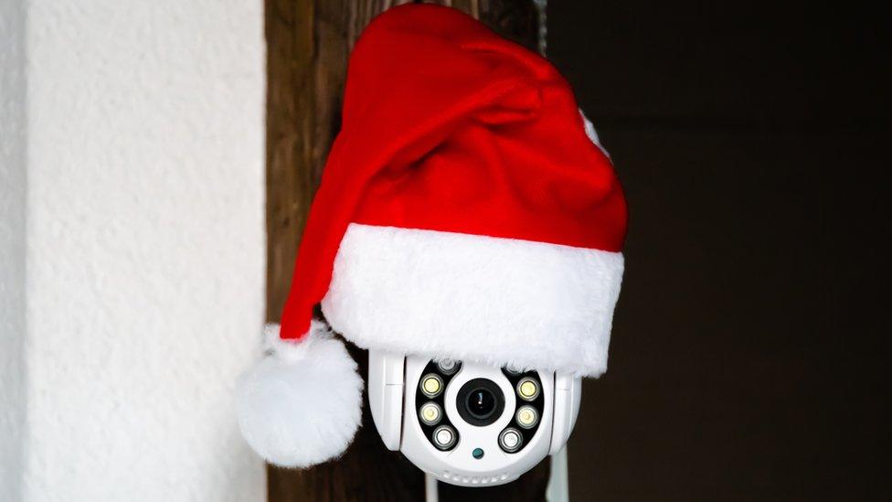 A home security camera with a Santa hat on it