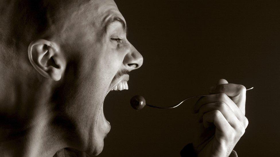 Man eats food on fork hungrily