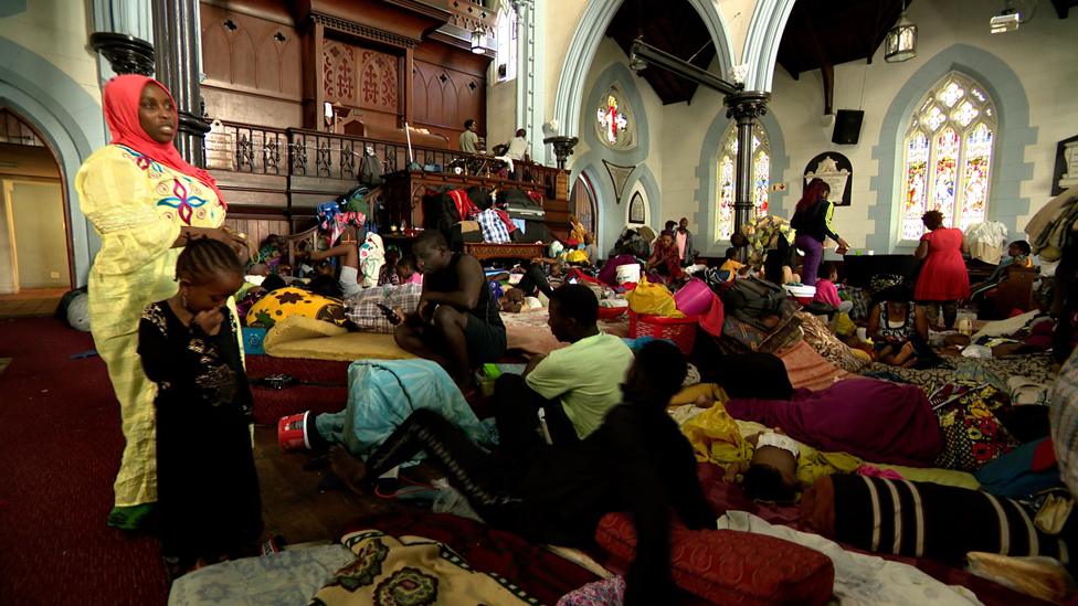 People and their belongings inside the church