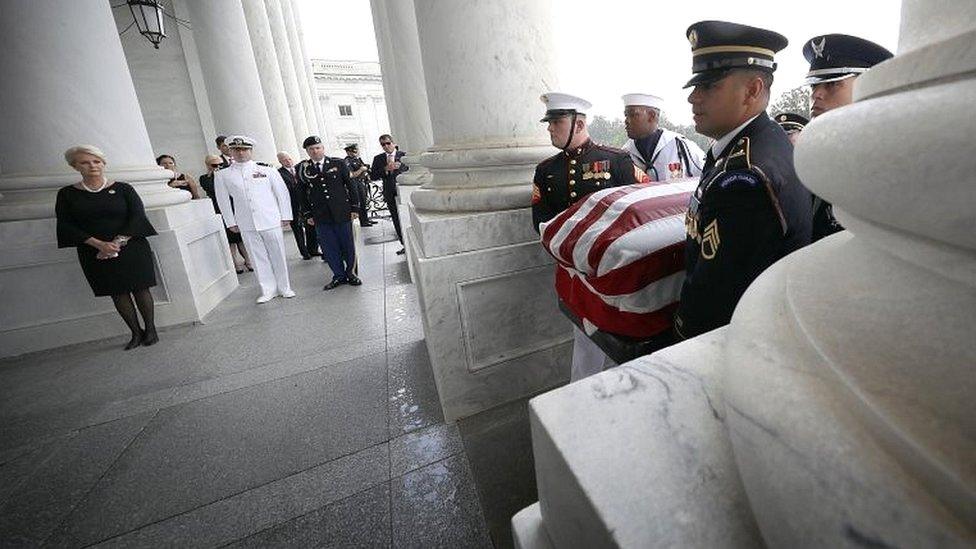 John McCain's widow Cindy McCain and his sons Jack (C) and James (R) watch joint service members of a military casket team carry the casket of Senator John McCain into the US Capitol in Washington DC on 31 August 2018