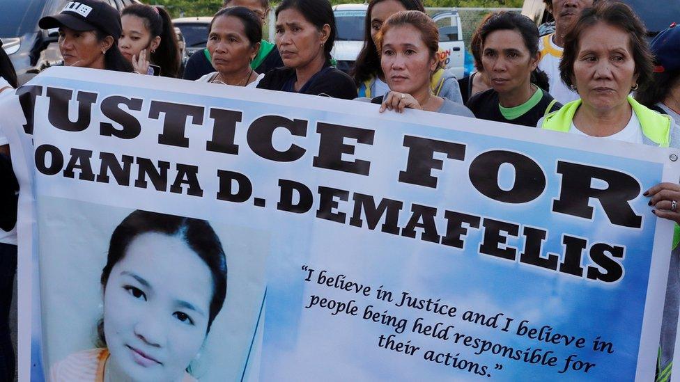 Women hold up a banner demanding justice for murdered Filipina maid Joanna Demafelis in Manila (17 February 2018)