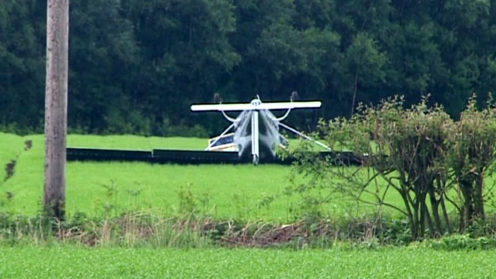 Plane lying upside down in a field