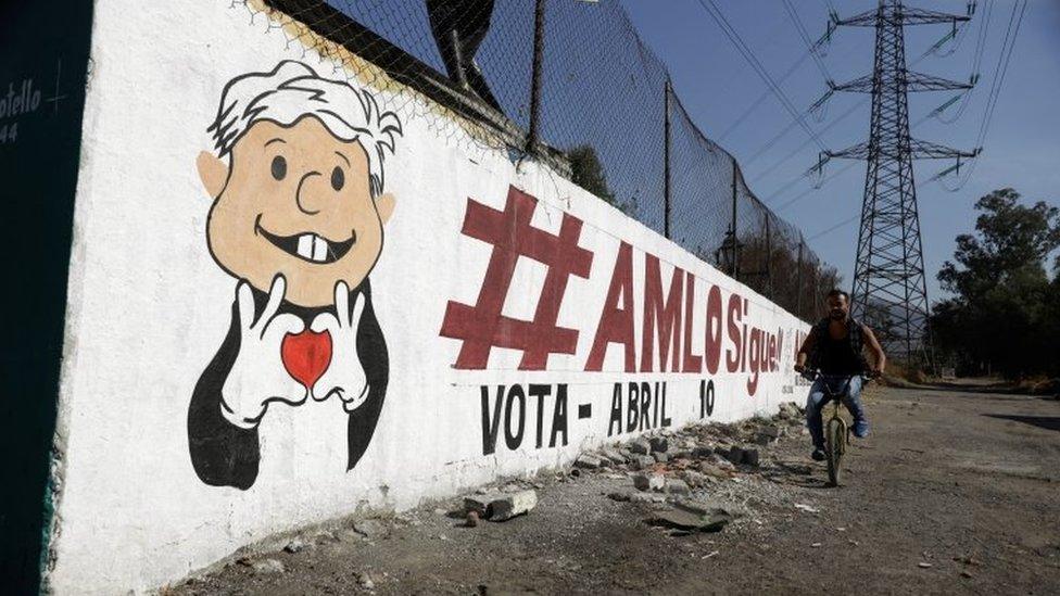 A man rides his bicycle past a mural promoting the April 10 recall referendum on the presidency of Mexican President Andres Manuel Lopez Obrador, in Mexico City, Mexico March 31, 2022.