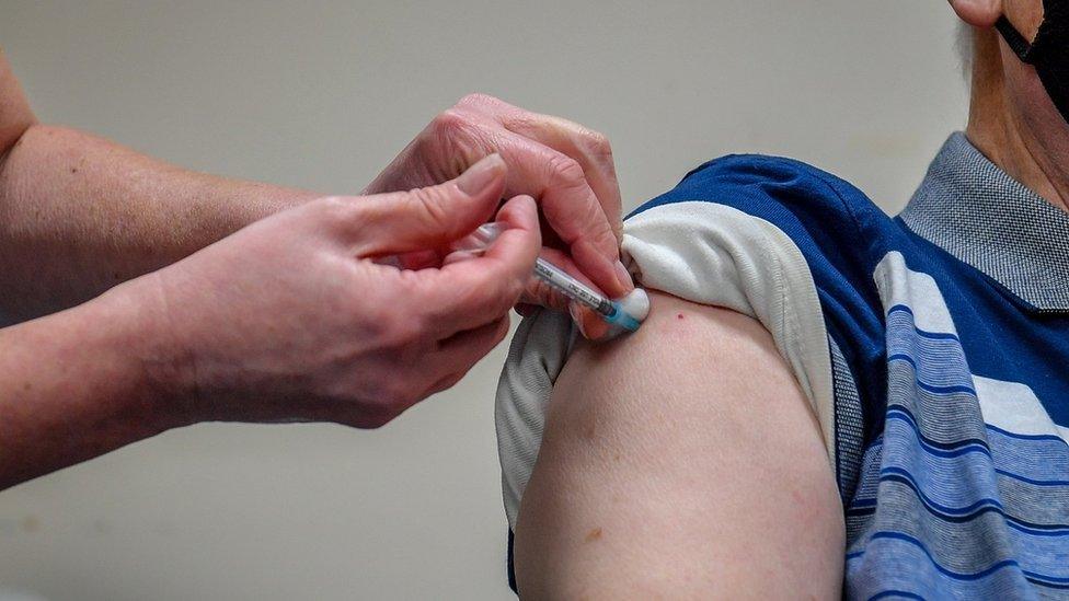 A man's arm receiving a Vaccination