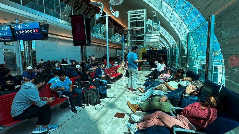 Passengers wait for their flights at the Dubai International Airport in Dubai