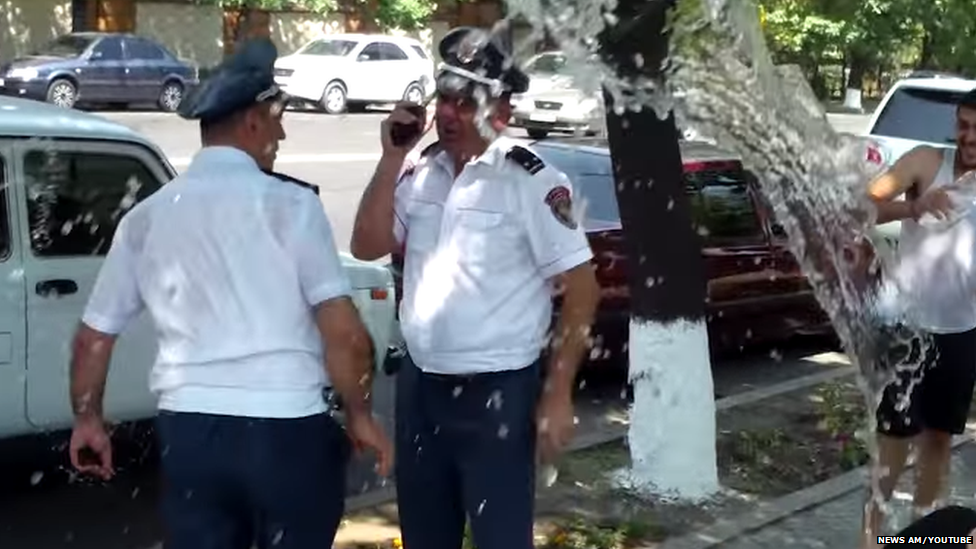 Two officers being soaked with water