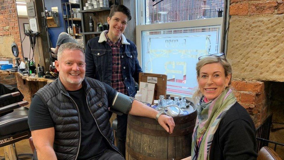 Barber Lee Tindle with public health specialist practitioners Kaye Mann (rear) and Louise Hunt who are offering free blood pressure checks to men while they wait for haircuts