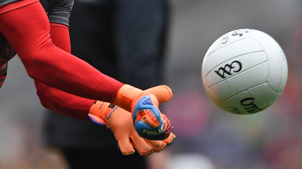 A man passing a Gaelic football