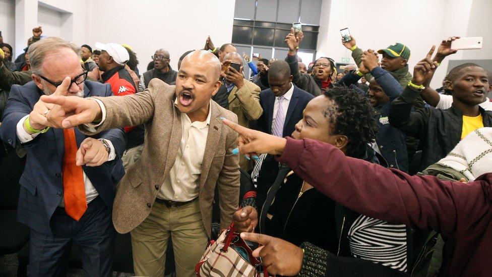 Supporters of former South African President Jacob Zuma sing and dance during a break in proceedings