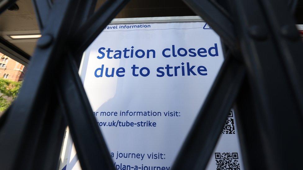 A sign can be seen through a closed gate at King's Cross St Pancras underground station in London, as train services continue to be disrupted following the nationwide strike