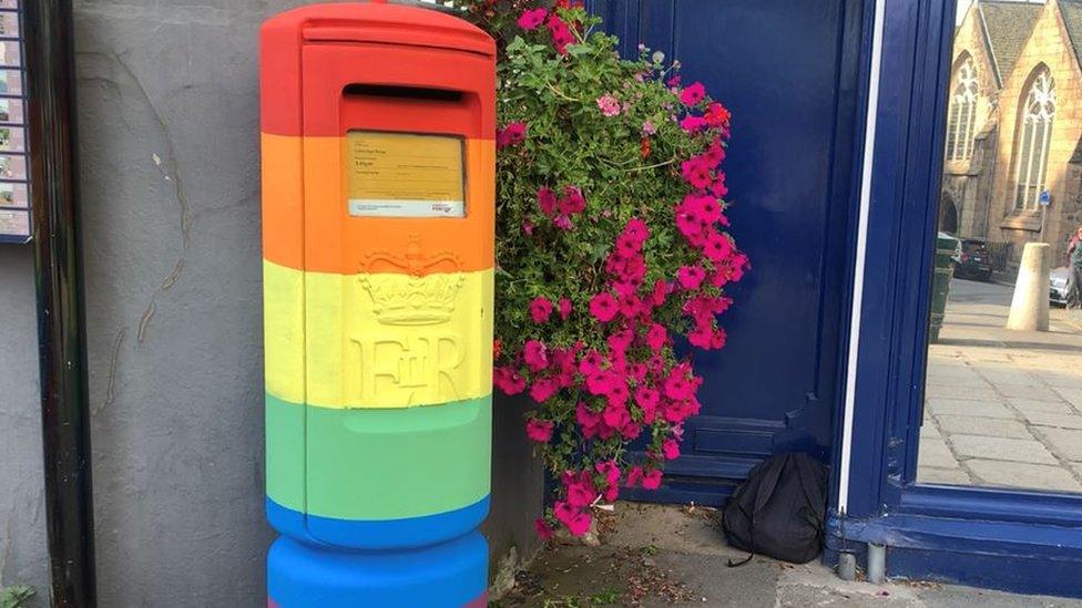 Guernsey post box painted in the colours of the rainbow flag