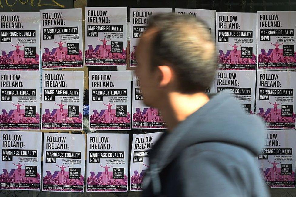 A passer-by walks past posters campaigning in favour of same-sex marriage