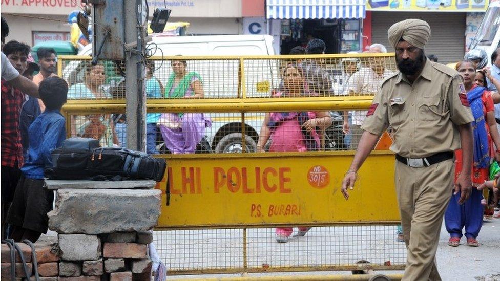 Indian people gather near the house where 11 members of a family were found dead in Delhi, India, 02 July 2018.