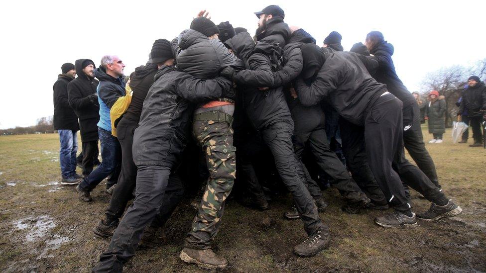 Two teams of the Alpha Men Assemble group interlock arms and work together to offer peaceful resistance against each other on January 8, 2022 in Brownhills, England.