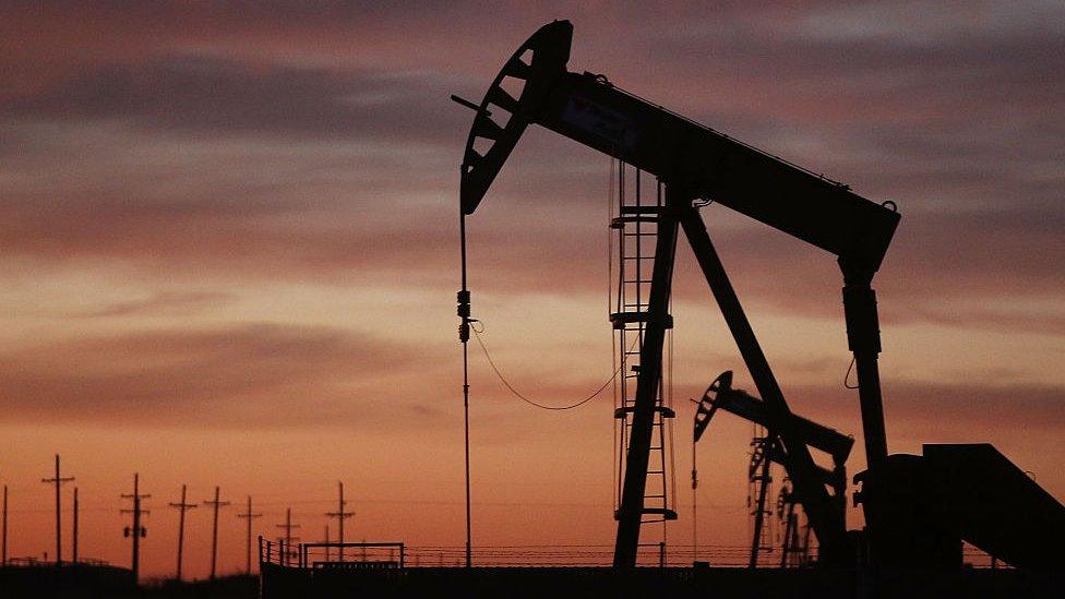 An oil pumpjack works at dawn in the Permian Basin oil field on January 20, 2016 in the oil town of Andrews, Texas.