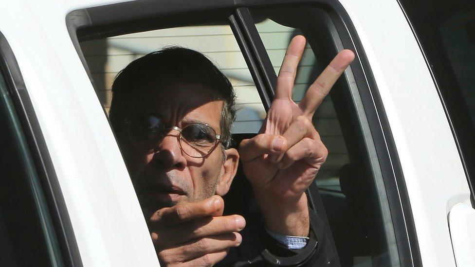 Mustafa giving a V-sign as he is driven away