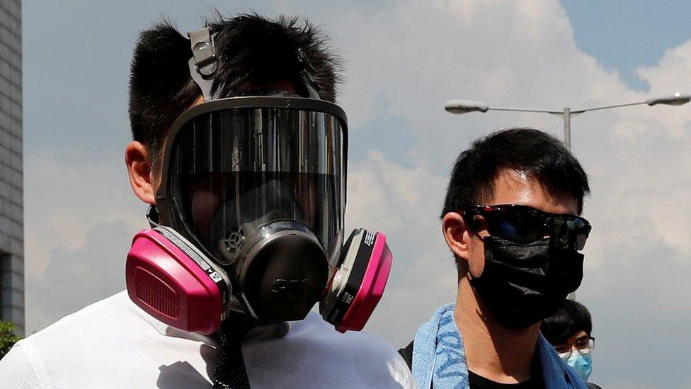 Anti-government office workers wearing masks attend a lunch time protest, after local media reported on an expected ban on face masks under emergency law, at Central, in Hong Kong