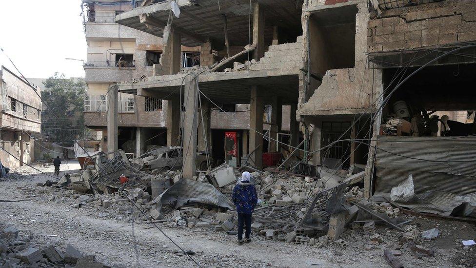 A Syrian girl looks at the rubble of a hospital that was destroyed in a reported government air strike in Hamouria, in the besieged rebel-held Eastern Ghouta (21 February 2018)