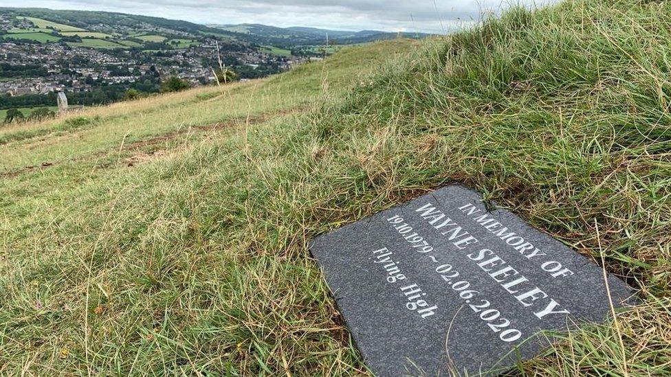 The memorial stone with his name on it and the words fly high