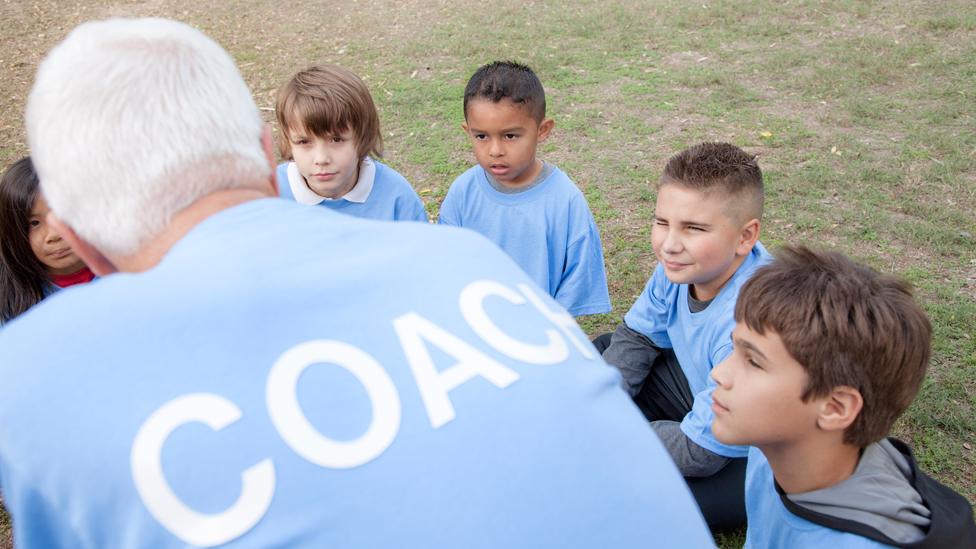 Coach talks to children (actors)