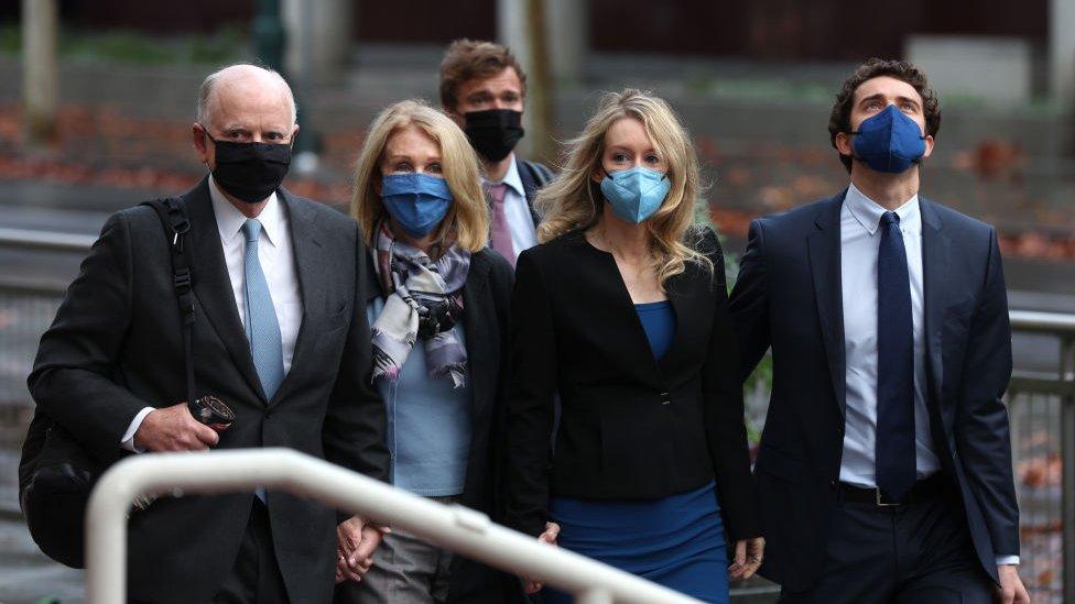 Eliabeth Holmes walks to court with her parents and her partner