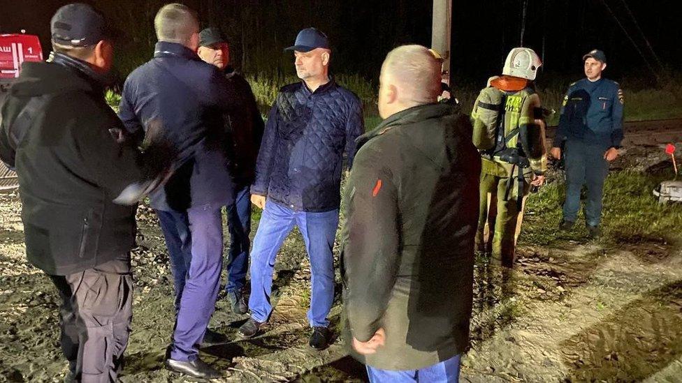 Officials and emergency workers visiting the site of the derailment