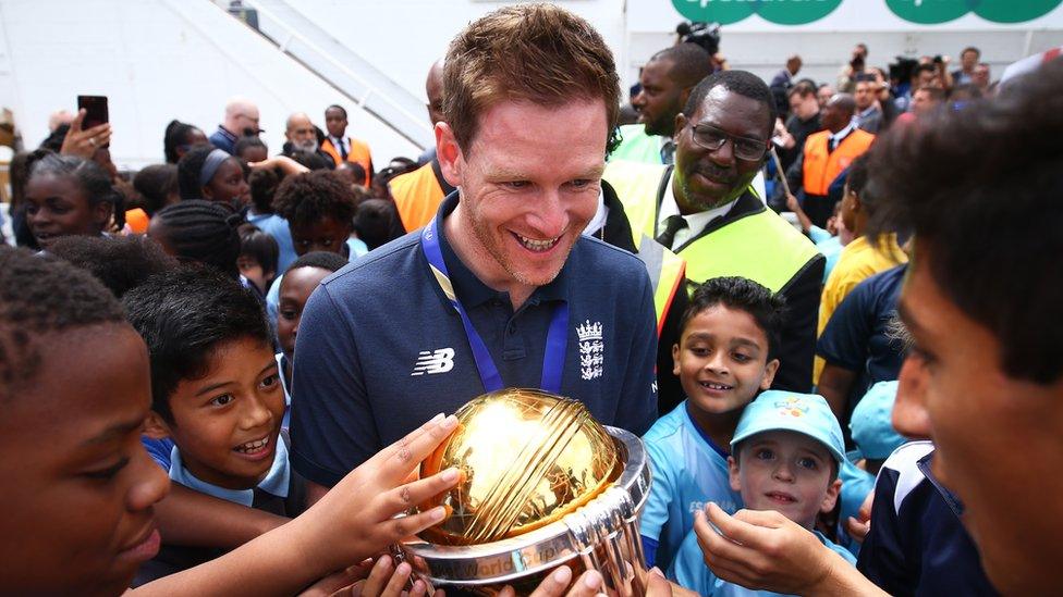 Eoin Morgan parades the trophy with young fans during the England ICC World Cup victory celebration at The Kia Oval on 15 July