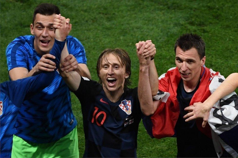 Croatia's midfielder Luka Modric (C) and Croatia's forward Mario Mandzukic (R) celebrate after winning the Russia 2018 World Cup semi-final football match between Croatia and England at the Luzhniki Stadium in Moscow on 11 July 2018.