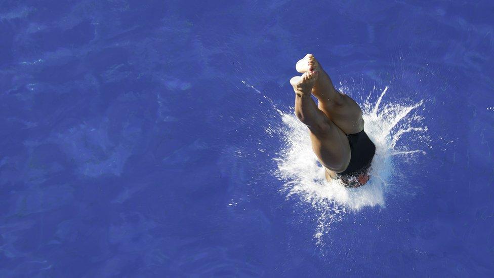 A swimmer diving into water