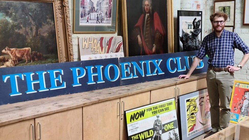 Auctioneer James Warren with the Phoenix Club sign