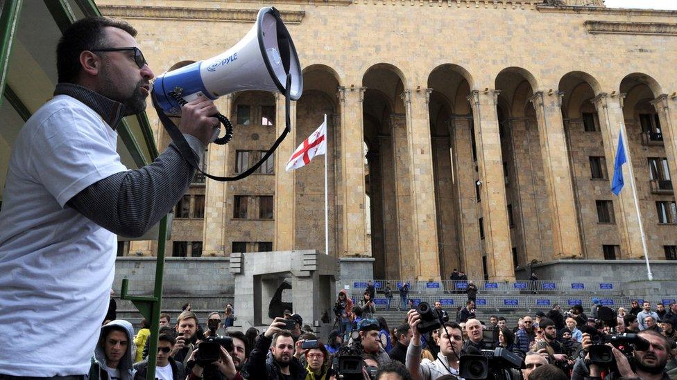 A Georgian opposition supporter shouts slogans during a protest rally against the sex tape leaks