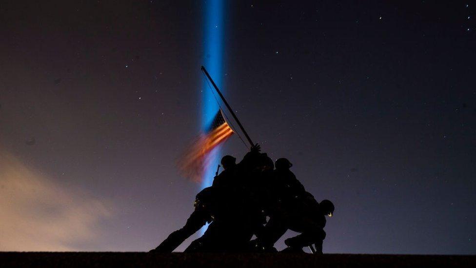 Pillars of light illuminate the sky behind the United States Marine Corps War Memorial, on the eve of the Inauguration of President-elect Joe Biden, the United States 46th president, on Tuesday, January 19, 2021, in Arlington, VA