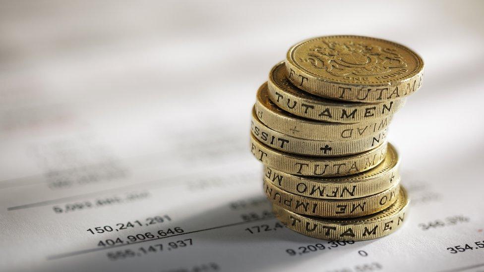 Stack of pound coins on financial figures