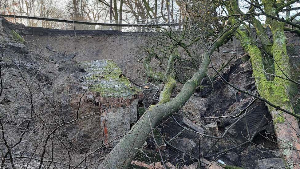 View of the landslip on Haslingden Old Road from the bottom of where the road has collapsed, showing soil, trees and rubble