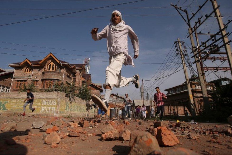 Kashmiris run for cover as Indian security forces (not pictured) fire teargas shells during clashes, after scrapping of the special constitutional status for Kashmir by the Indian government, in Srinagar, September 6, 2019