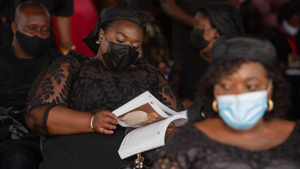 A woman looks through a brochure at the final funeral rites of Ghana's former President Jerry John Rawlings in Accra, Ghana, on January 27, 2021.