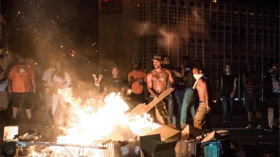 People put cargo from tractor trailers on a fire on the I-85 (Interstate 85) during protests following the death of a man shot by a police officer in Charlotte, North Carolina.