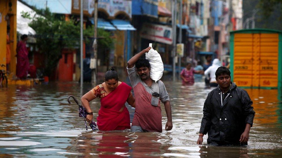 People wading through flooded street