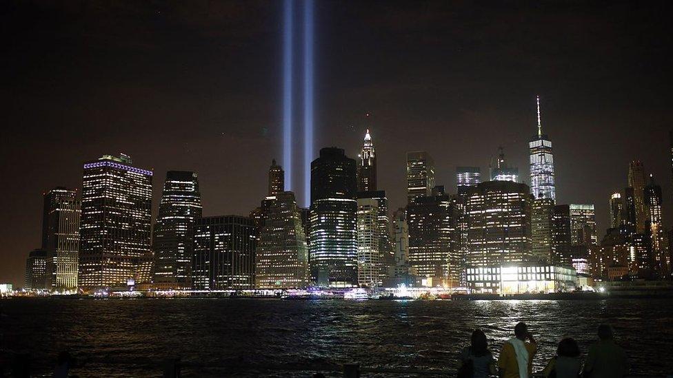 Two beams of light light up the sky as part of the New York City skyline, in tribute to the twin towers and the vicitms of 9/11.