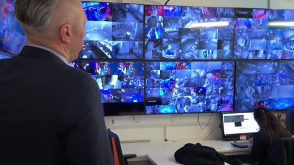 A member of staff at Tiger Tiger looks at a wall of CCTV screens in a back room