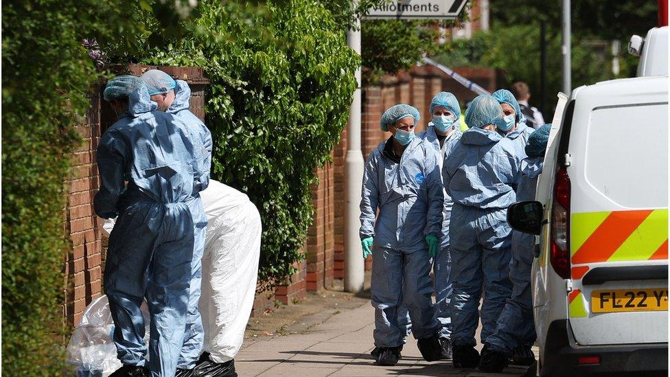 Forensic officers work at the scene of an incident