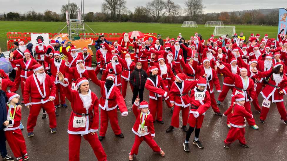 People dressed in Santa costumes dancing