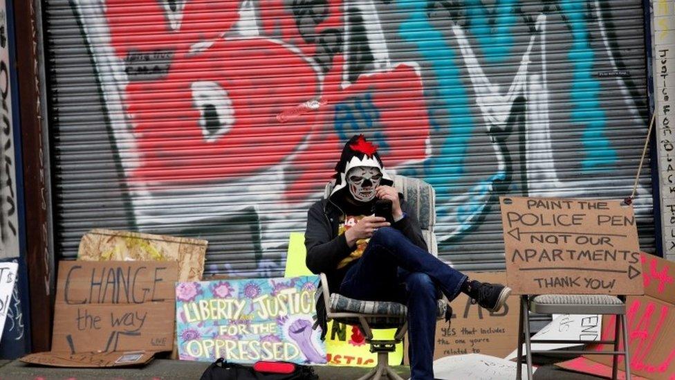 A demonstrator sits at the self-proclaimed Capitol Hill Autonomous Zone