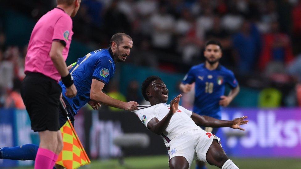 Giorgio Chiellini of Italy fouls Bukayo Saka