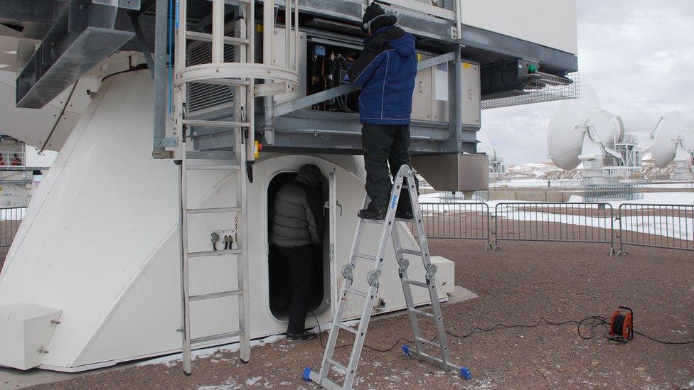 Engineers working on one of the dishes