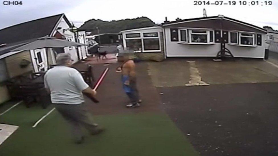 Christopher Joyce threatens a man with a broom