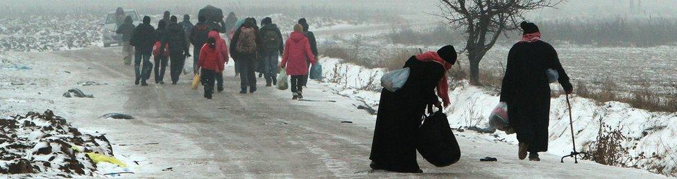 Migrants travel on foot through the snow and cold weather from Macedonia to a camp on the border with Serbia (5 Jan)