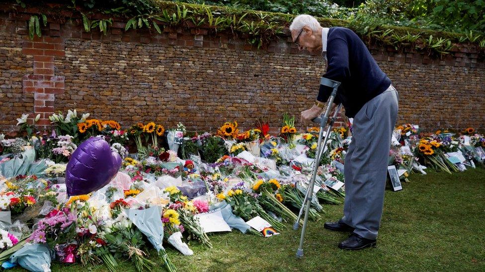 A man looks at floral tributes left at the Sandringham Estate