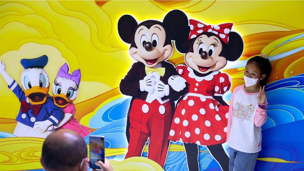 A child poses for a photo at the booth of Shanghai Disney Resort during an exhibition of the 2nd China (Wuhan) Culture and Tourism Expo on April 22, 2023 in Wuhan, Hubei Province of China.